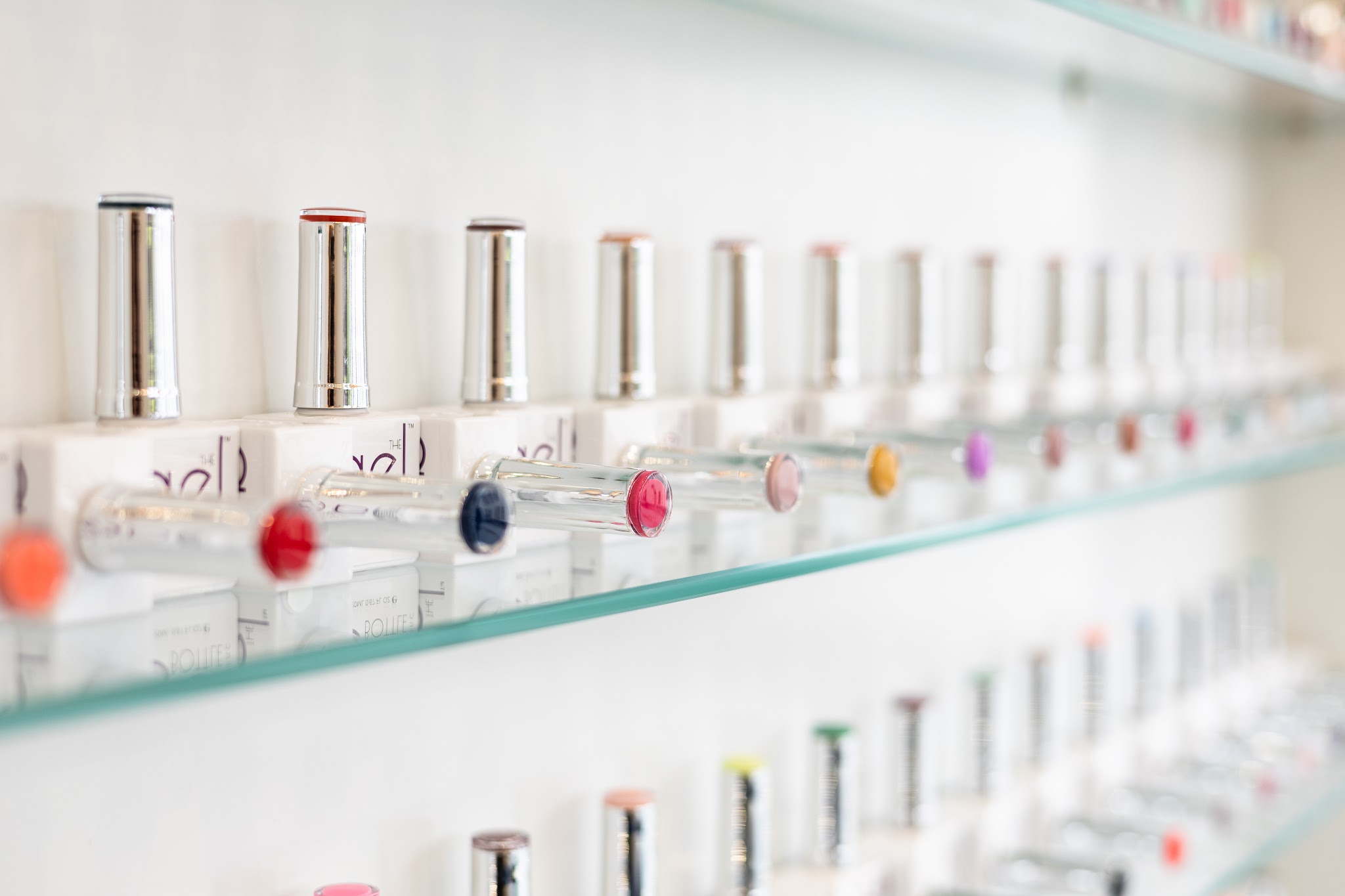 Rows of gel polish colours on the salon’s glass shelves