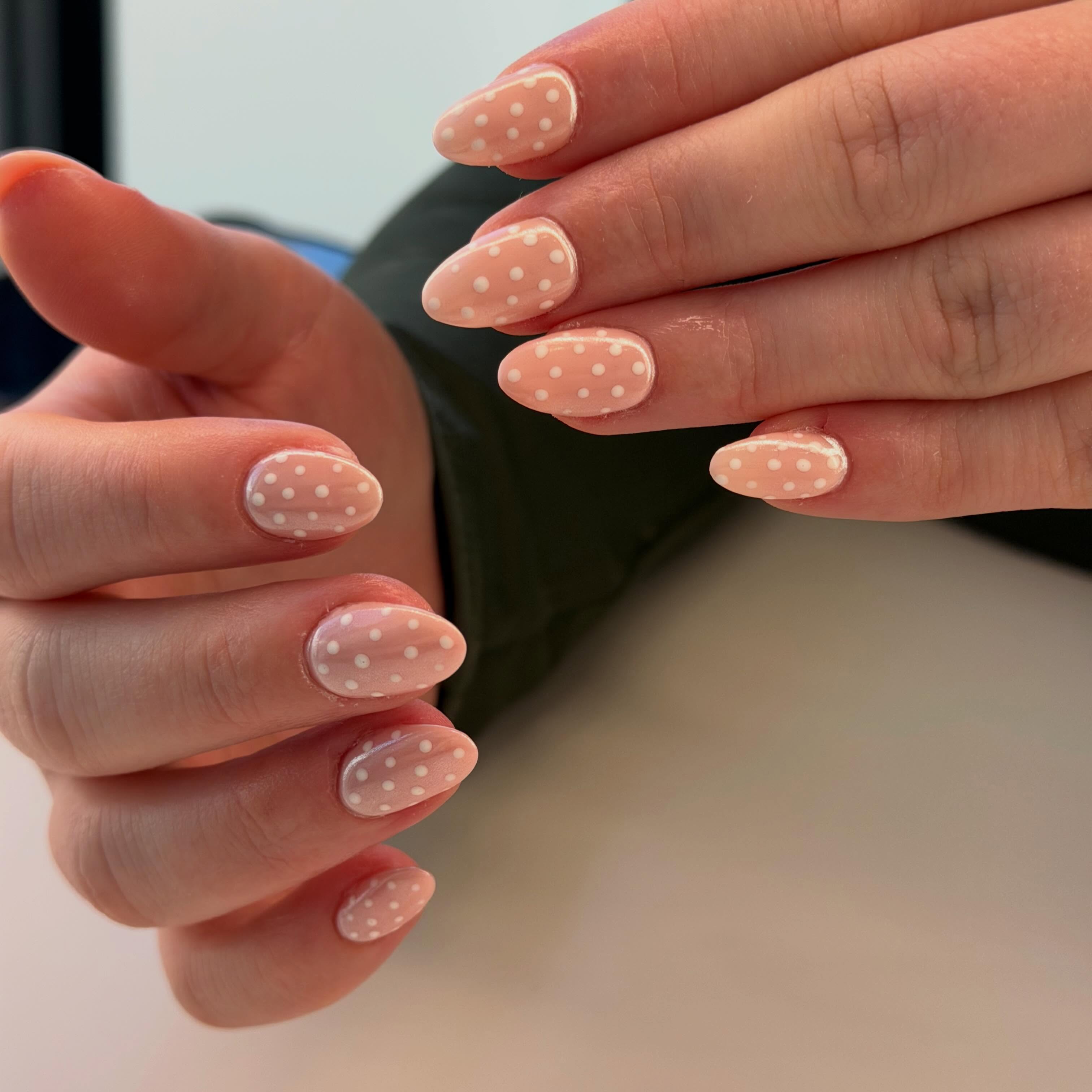 Peach nails with white polka dots