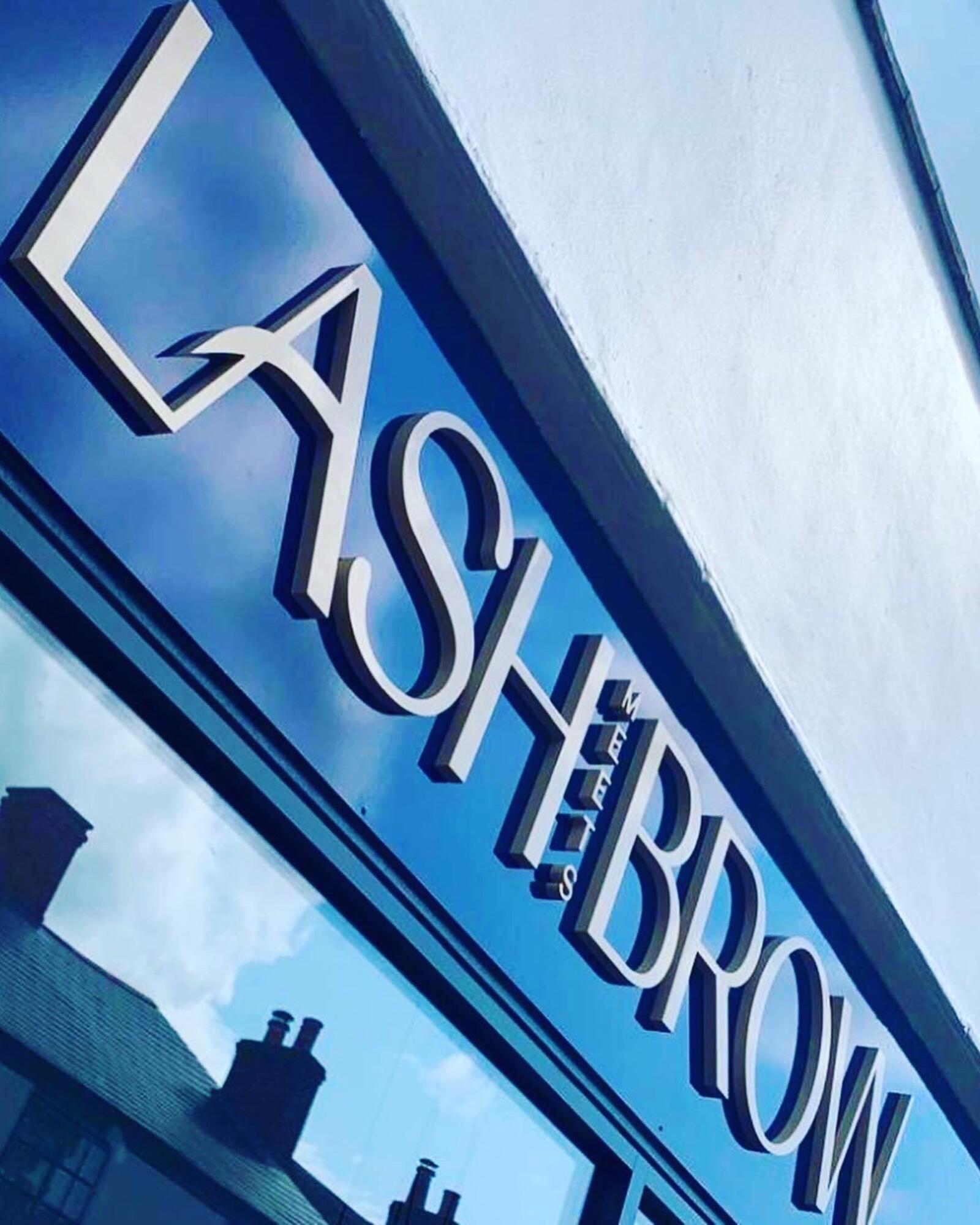 The Lash Meets Brow lettering on the shop fascia against a blue sky