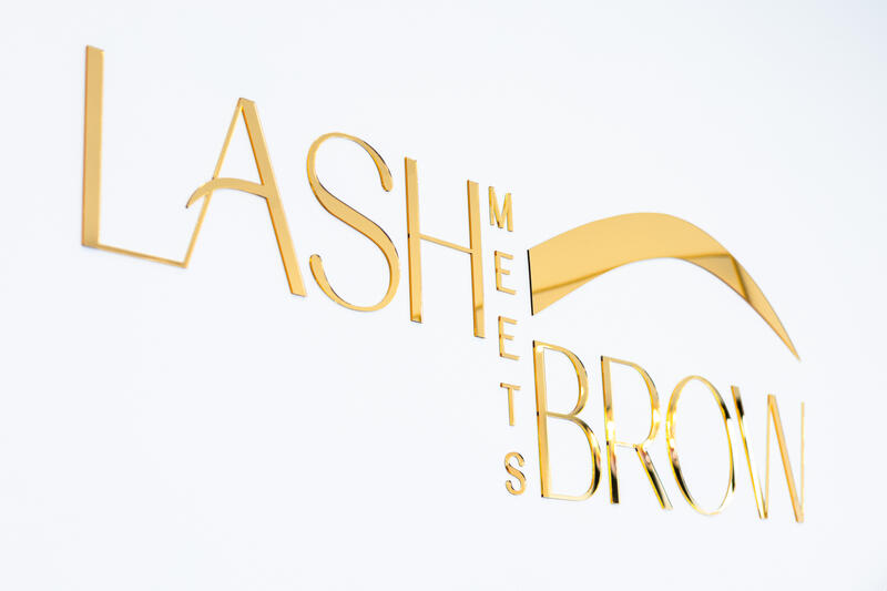 The gold Lash Meets Brow sign on the salon wall